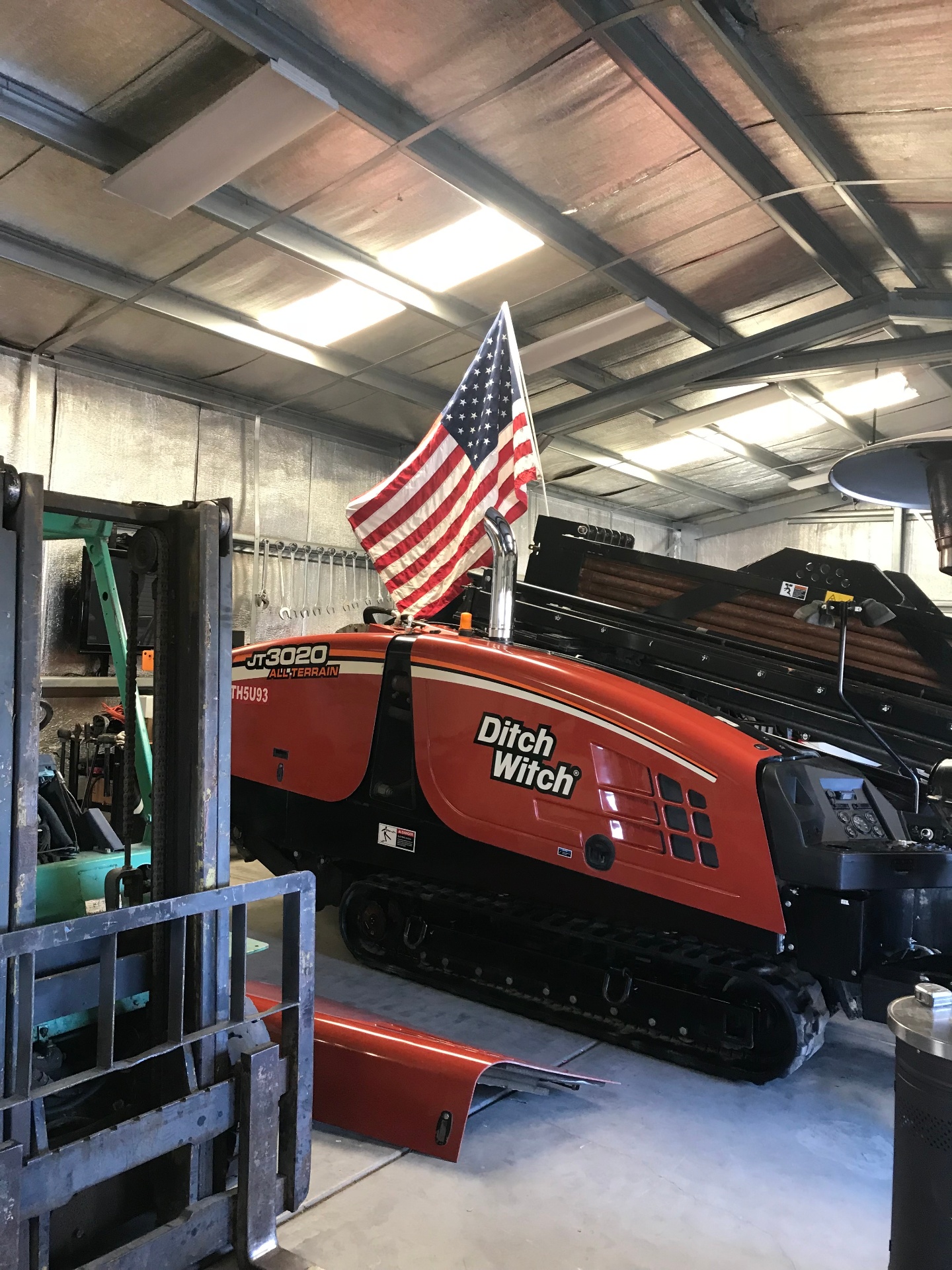 Ditch Witch JT3020 All-Terrain rig parked in the shop under the American flag
